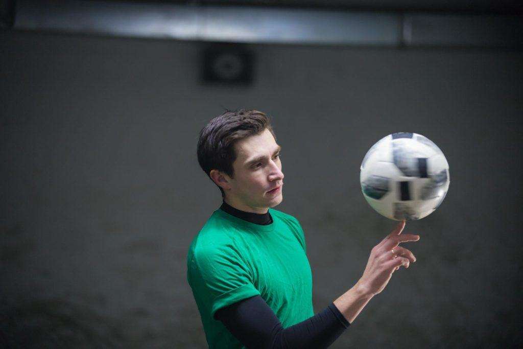 concentrated-soccer-player-training-his-skills-with-ball-spinning-ball-finger