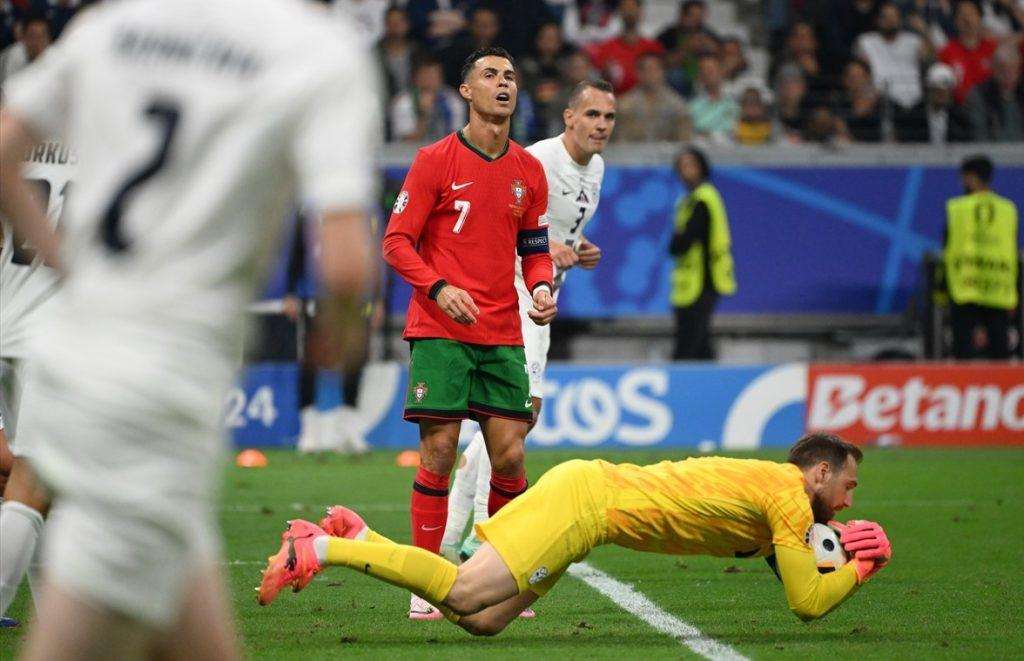 Intervencija vratara Slovenije Jana Oblaka ispred kapetana Portugala Cristiana Ronalda / Foto: Anadolu