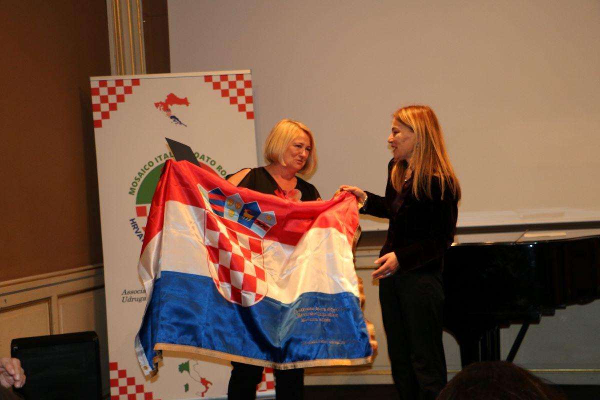 HRVATSKO-TALIJANSKI MOZAIK RIM PROSLAVIO 10. OBLJETNICU UZ JASNU PORUKU: Mladi su naš najdragocjeniji resurs, veza s Hrvatima u domovini i svijetu neophodna Predsjednica HKU Bremen Ljiljana Vidović darovala je predsjednici Ivani Milina poseban dar, hrvatsku zastavu s izvezenom čestitkom / Foto: Fenix /MD
