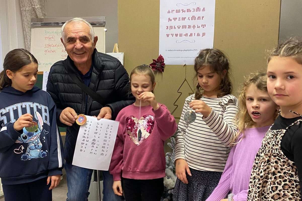 GLAGOLJICA NA BOŽIĆNOJ JELKI: Učenici hrvatske nastave u Mainzu izrađivali božićne ukrase, pomogao im vrsni poznavatelj glagoljice Tomislav Parlov-Tone Tomislav Parlov – Tone je djeci objašnjavao slova glagoljice / Foto: Fenix (JA)